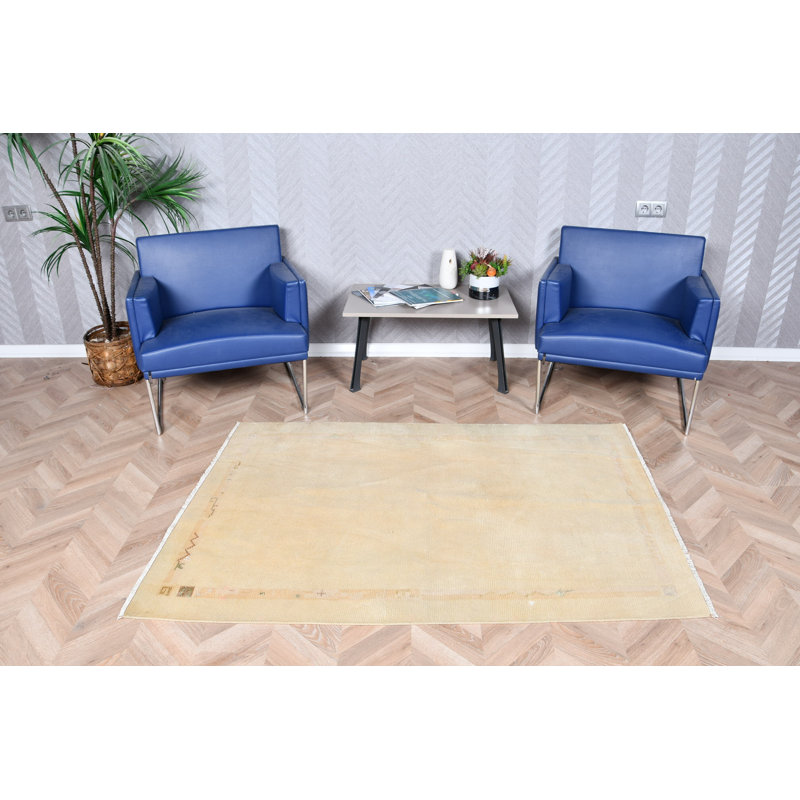 Tapis décoratif subtil à motifs géométriques dans des tons de jaune doux, idéal pour un décor rétro de Turquie