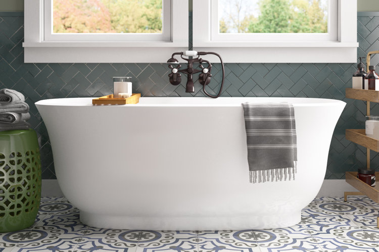 bathtub in a traditional bathroom with black and white mosaic floor tiles