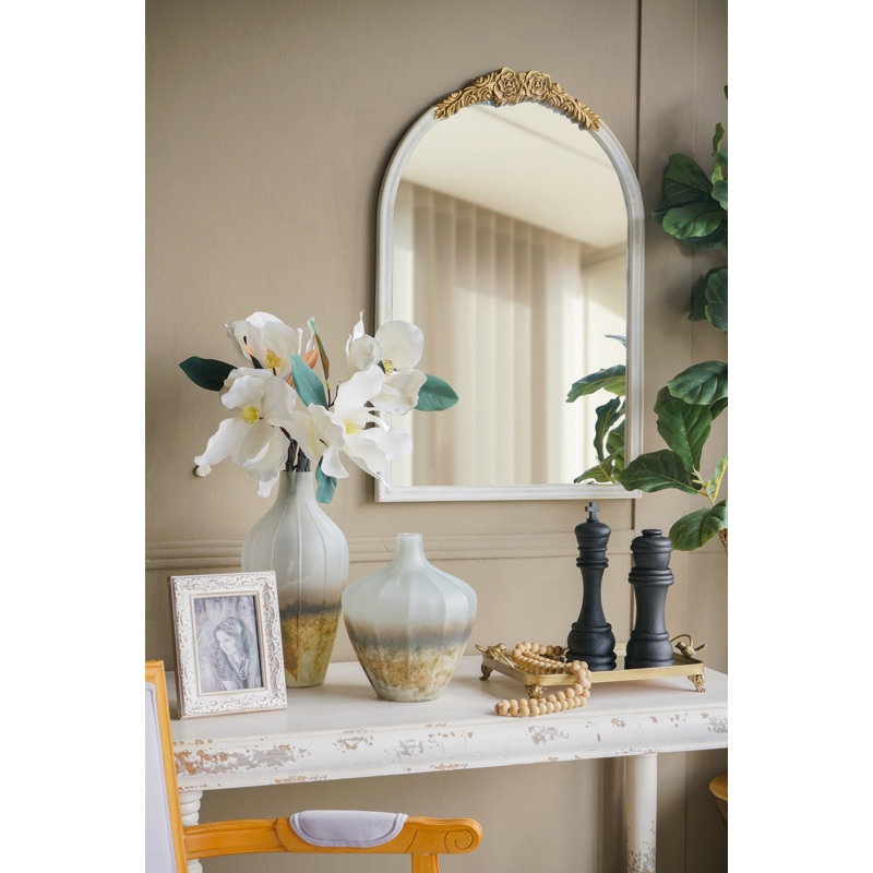 Miroir mural orné de style champêtre français avec écusson floral doré et cadre blanc vieilli pour le décor de la chambre à coucher