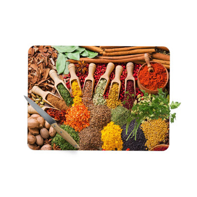 Motif d'épices colorées sur une planche de service en verre moderne, idéal pour la cuisine