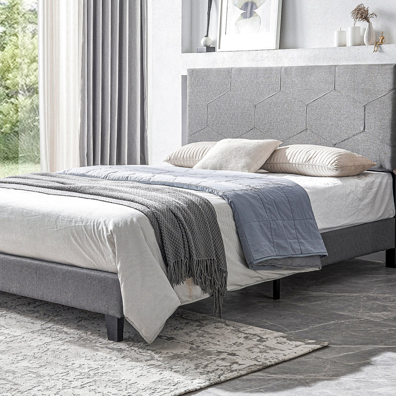 Lit tapissier grand, gris, avec support de lit en lattes de bois gris, offrant un confort optimal