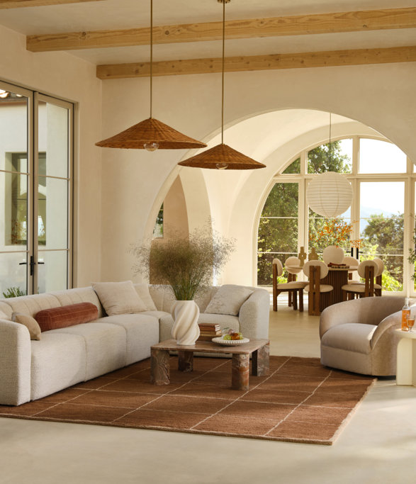 A well-decorated living and dining room with brown and beige accents.