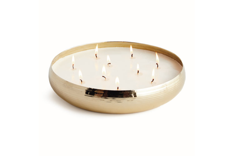 A a round gold candle with ten individual wicks each lit with a flame.