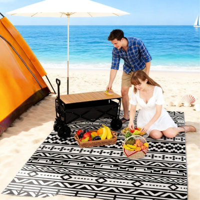 Tapis d'extérieur à motif géométrique, réversible et facile d'entretien, idéal pour le camping. Doté de quatre attaches à boucle aux coins, il est empilable et résistant au vent. Fabriqué en polypropylène, il est parfait pour la plage.