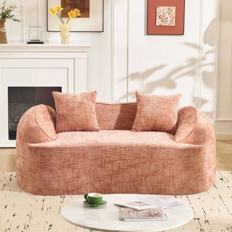 Canapé courbé pour deux personnes. Il a des accoudoirs des deux côtés, est livré avec deux coussins, Chenille rose