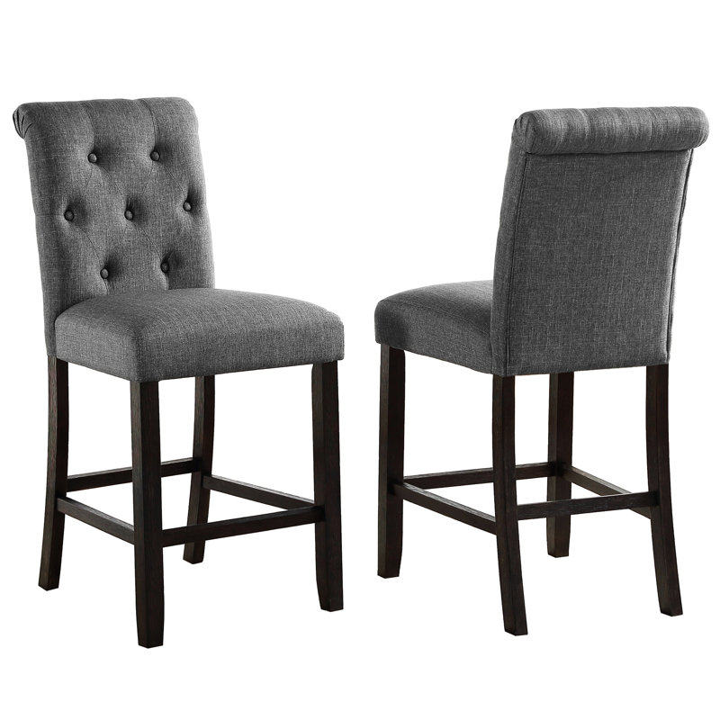 2 pièces tabouret de comptoir gris. Bois massif avec sièges et dossiers élégants. Rembourré pour un confort maximal. Pieds en bois au fini foncé. Chaises à haut dossier délicatement courbées. L 23 po x P 19 po et H 40,92 po. Siège: l 19 po