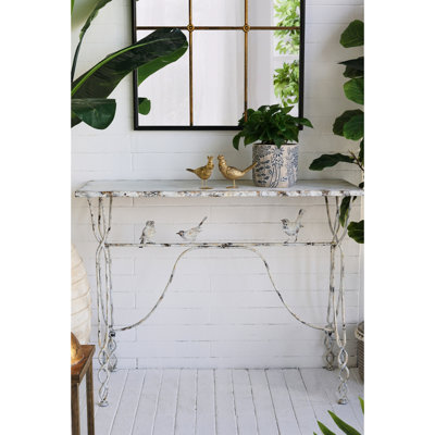 Console de 109 x 42 x 86 cm avec perchoir pour oiseau en fer vieilli, pieds torsadés, aspect blanc patiné. Un élément décoratif fantaisiste pour une entrée ou un couloir.