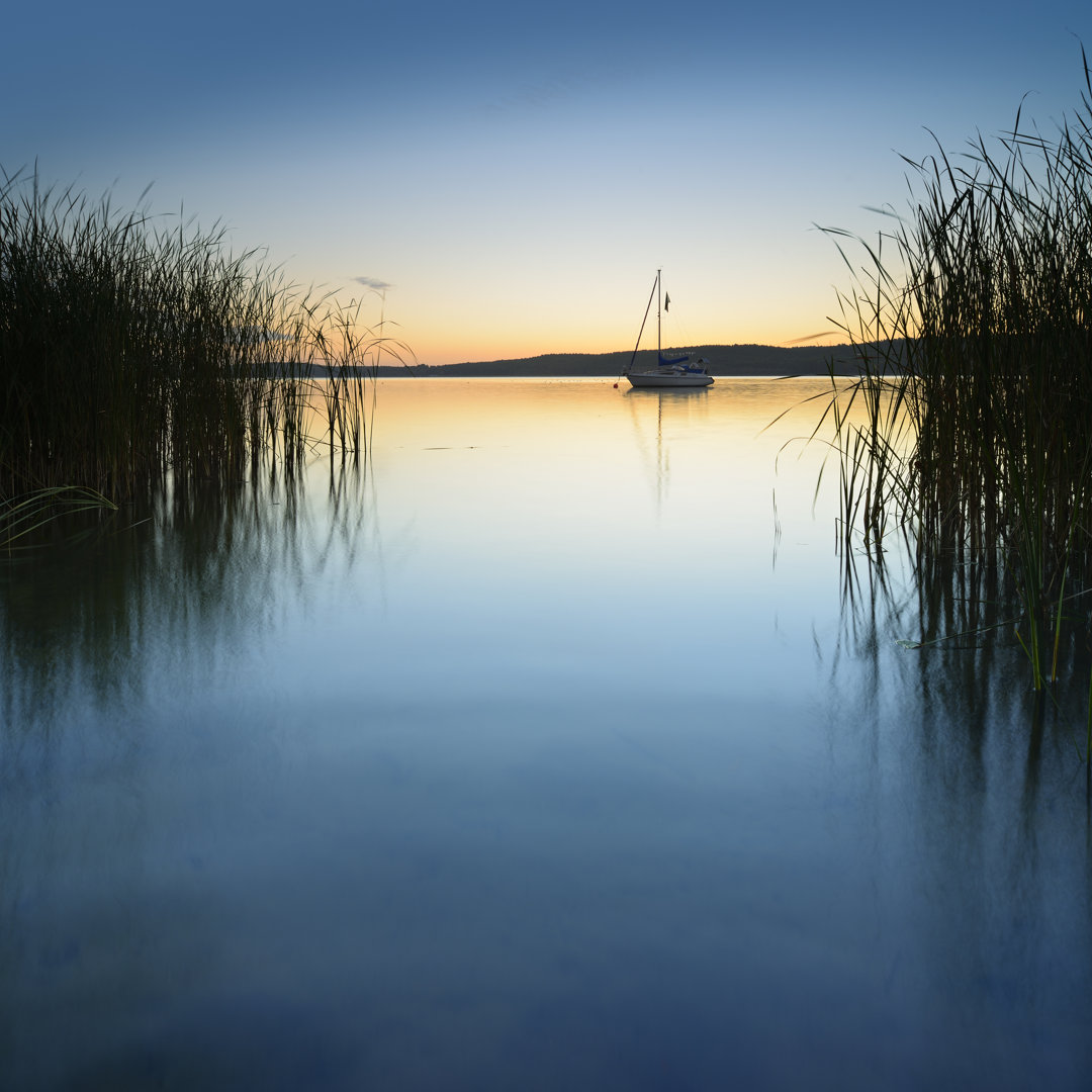 Segelboot auf ruhigem See bei Sonnenaufgang - Leinwandbild