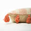 Coussin décoratif bohème en coton orange et crème tissé à la main avec pompons