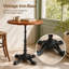 Table de bistro ronde vintage, plateau en pin massif, piètement en fonte à quatre pattes pointues, noire