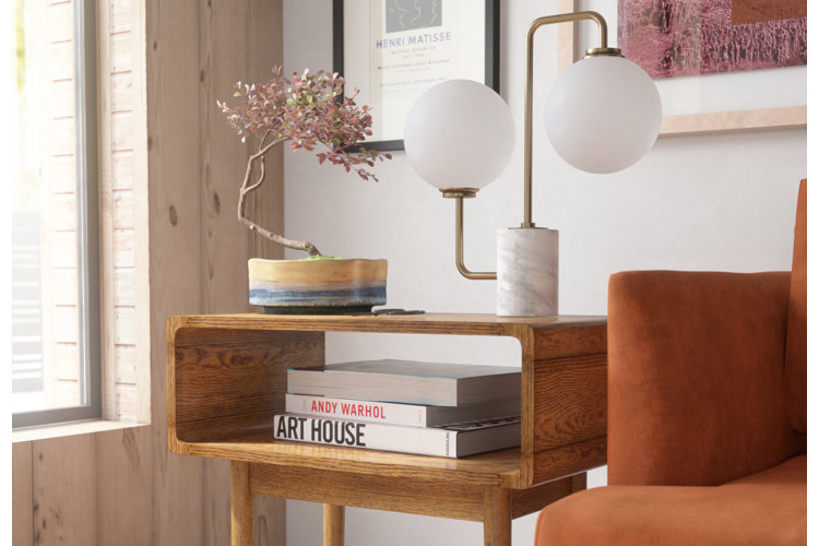Contemporary table lamp and potted plant on an end table.