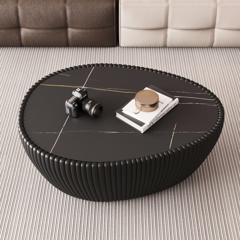 Table basse en cuir en forme d'œuf d'oie avec plateau en pierre frittée noire, stable et élégante, idéale comme table d'appoint dans une chambre ou un bureau.
