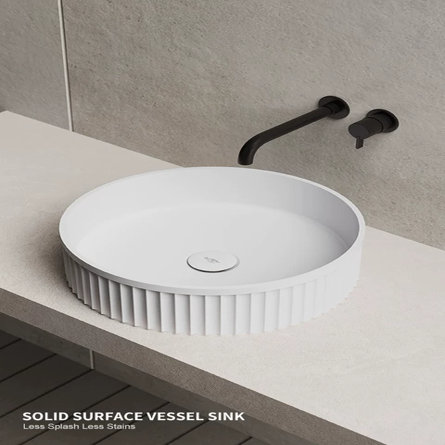 White round ribbed vessel sink on a stone countertop with a matte black wall-mounted faucet, featuring the text SOLID SURFACE VESSEL SINK, Less Splash Less Stains.