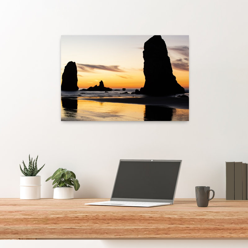 Silhouettes Of Rock Formations At Sunset At Cannon Beach Oregon USA by Dan Merkel - Wrapped Canvas Print