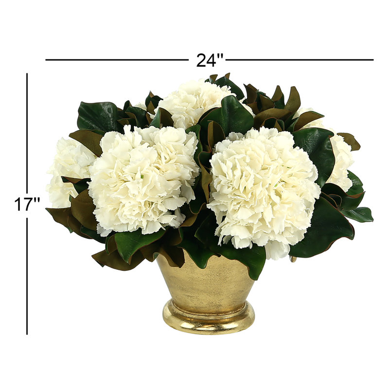Arrangement d'hortensias et de feuilles de magnolia dans un vase en métal