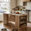 Îlot de cuisine de 155 cm de large avec dessus en faux marbre, tablettes latérales ouvertes, bande lumineuse DEL et prise électrique.