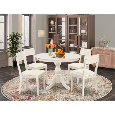 L'ensemble de salle à manger 5 pièces comprend une table de salle à manger ronde avec piédestal et 4 chaises en similicuir, blanc lin