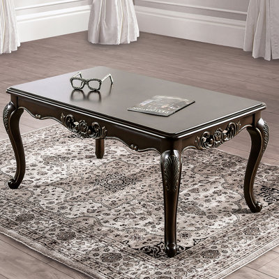 Table basse de style traditionnel avec des pieds courbés, une conception sculptée et une structure en bois massif avec une finition Java riche