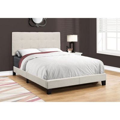 Lit double avec magnifique revêtement en lin beige et pieds revêtus de bois noir pour la chambre à coucher