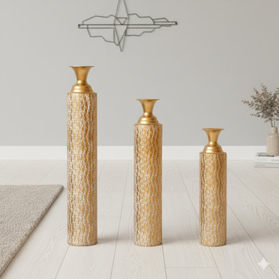 A Set Of Three Tall Metal Vases With A Highly Distressed Finish And Intricate Climbing Vine Designs. Perfect For Home Decoration, The Vases Stand At 34, 29, And 25 Inches In Height And Feature A Gold Tone.