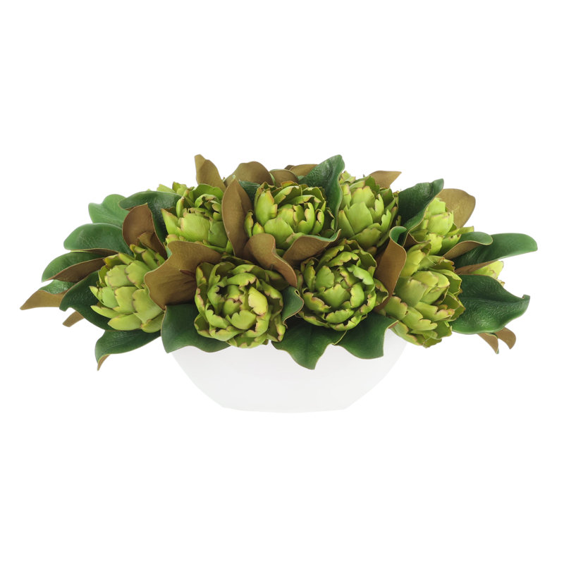 Arrangements floraux de magnolia et d'artichaut dans un pot en fibre de pierre