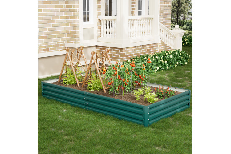 green galvanized steel raised garden bed behind a brick house