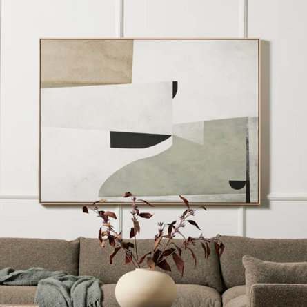 Abstract art above a brown couch in a living room.
