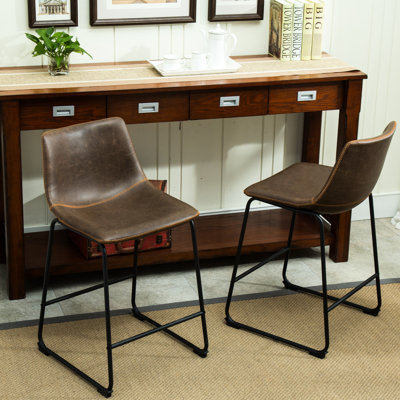 De 2 tabourets de comptoir en cuir brun antique. Fabriqué à la main avec base en plastique et en polyuréthane rétro. Cadre en fer noir. Dimensions: l 18,5 po x P 21,5 po x H 34,5 po. Siège: 2 tabourets de H 24,5 po x P 15 po. Revêtement en cuir
