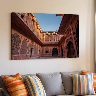 Toile, une scène de cour vibrante dans un palais historique mettant en vedette un art mural complexe en grès rose avec une œuvre d'art Jali
