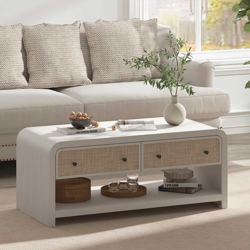Table basse blanche avec tiroirs en rotin et rangement ouvert