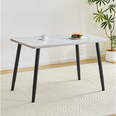 Table de salle à manger rectangulaire moderne et minimaliste, pouvant accueillir de 4 à 6 personnes. Comptoir en verre trempé + panneau de fibres à densité moyenne inférieur, texture imitation marbre, pieds fuselés en métal noir. Convient aux restaurants minimalistes.