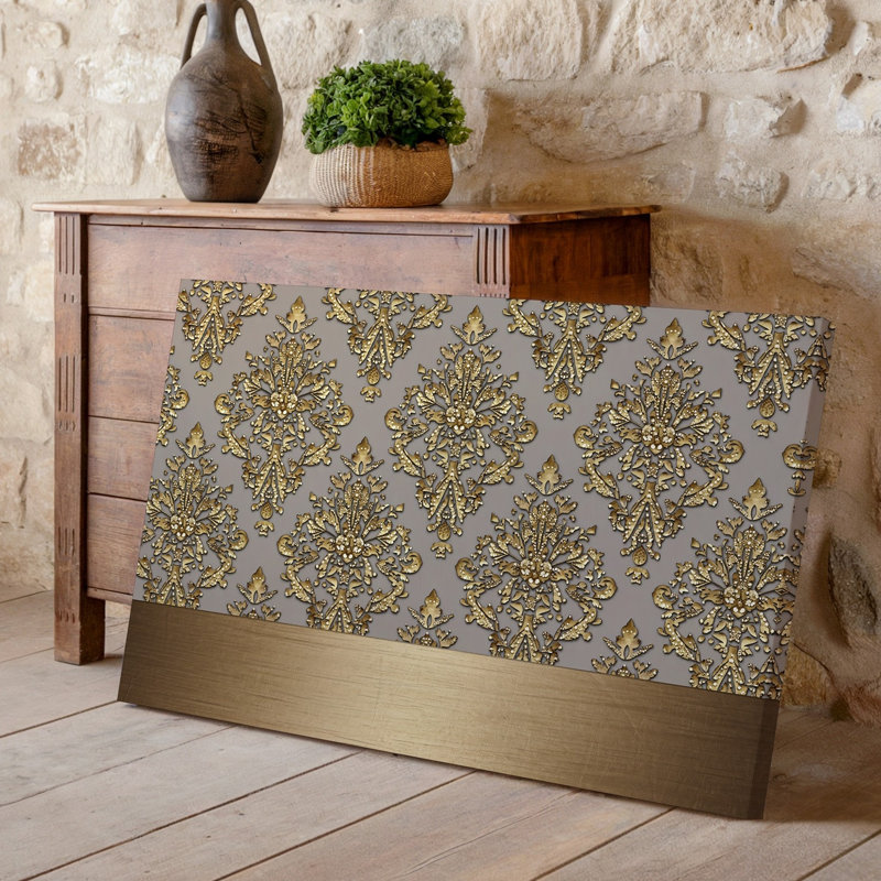 La toile crée un design de papier peint élégant avec un motif damassé complexe en or chatoyant contre un taupe doux