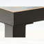 Table basse industrielle carrée avec structure en acier noir mat et plateau en verre doré pour les espaces de vie modernes