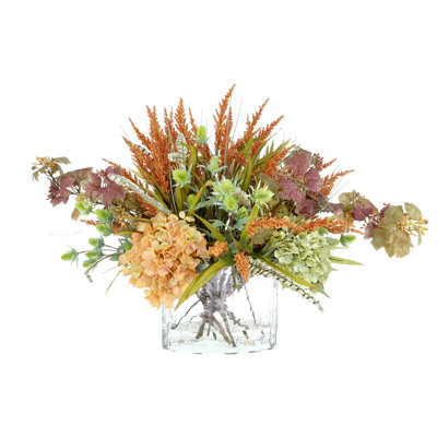 Heather, hortensia et chardon dans un vase en verre