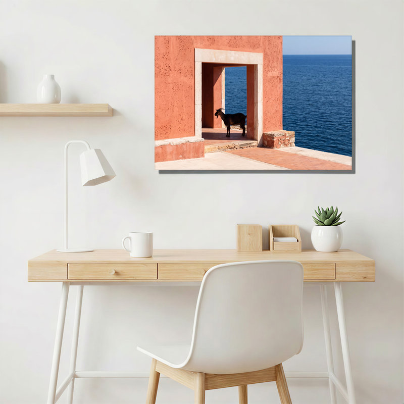 Chèvre noire debout dans une porte en terre cuite face à une toile bleue, 20"H x 30"W