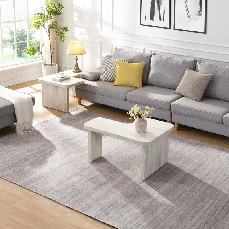 Table basse blanche en forme de L, 123 x 61 cm et 90 x 80 cm détachables, idéale pour un hall d'entrée, un jardin ou une salle à manger conviviale. Structure facile d'entretien.