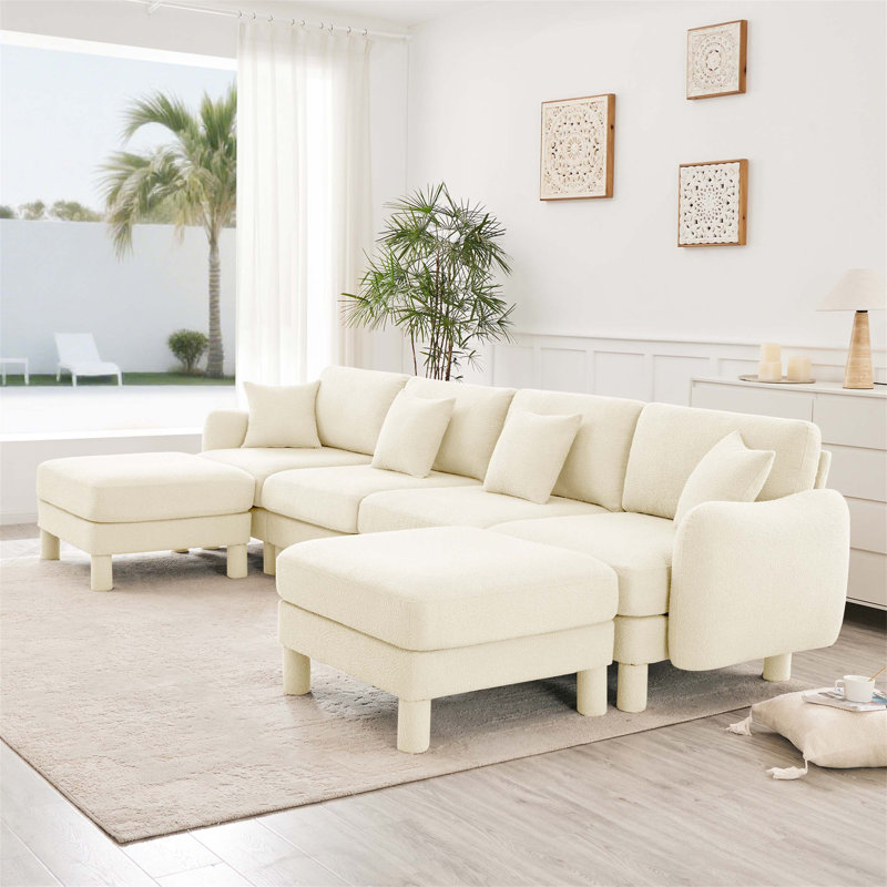 Canapé modulaire en U à 4 places avec accoudoirs en forme de coquillage, 2 repose-pieds mobiles et pieds cylindriques Boucle