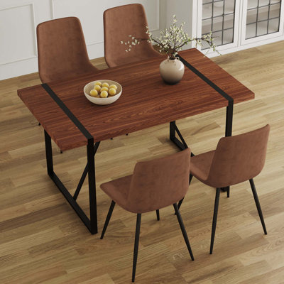 Ensemble de table et de chaises. Une table de salle à manger rectangulaire rétro minimaliste avec un dessus spécialement texturé et des pieds en métal, jumelée à des chaises douces et des pieds en métal, met en valeur un beau style de maison.