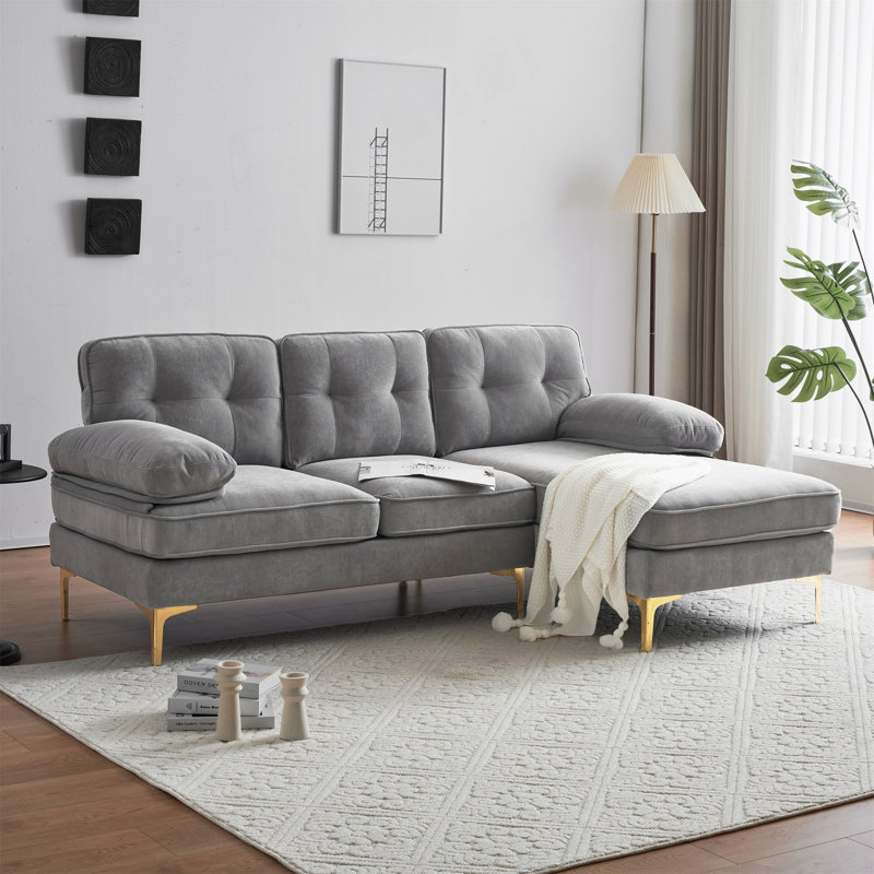 Canapé luxueux rembourré en forme de L en velours avec coussins amovibles et structure robuste, parfait pour les décors modernes et rétro.