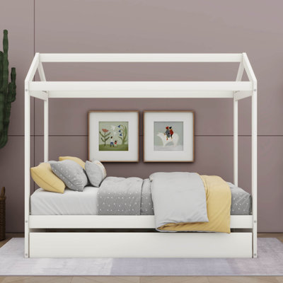 Un lit en forme de maison avec un lit gigogne sous le lit