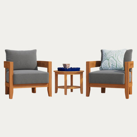 Two gray chairs on either side of a small wooden table with blue decor.