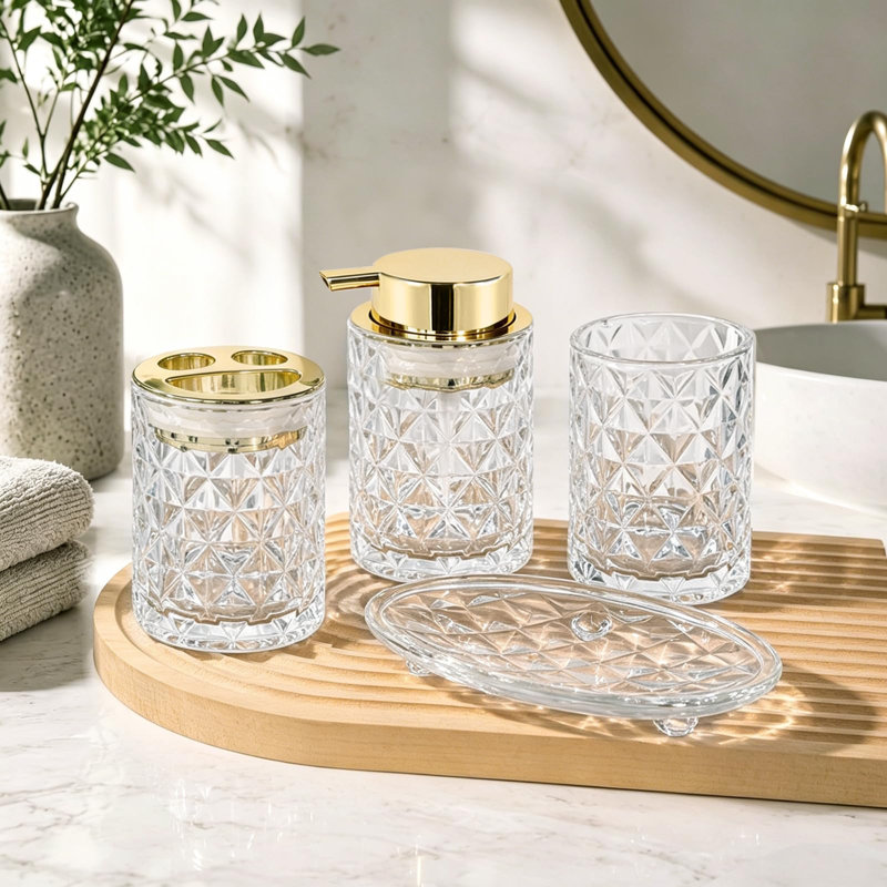 Ensemble de salle de bain en verre 4 pièces, blanc doré, comprenant un distributeur de savon, un porte-brosse à dents, un gobelet à brosse à dents et un porte-savon.