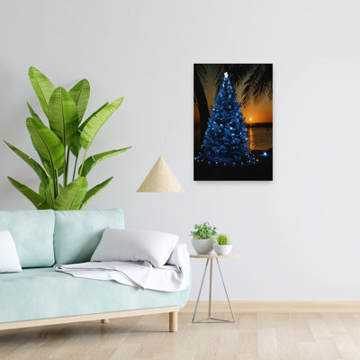 Arbre de Noël bleu des années 1970 avec lumières sur une plage tropicale au coucher du soleil