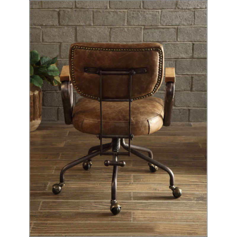 Fauteuil de bureau pivotant vintage en similicuir, orné de clous décoratifs, avec accoudoirs en bois et piètement en métal, sans relevage.