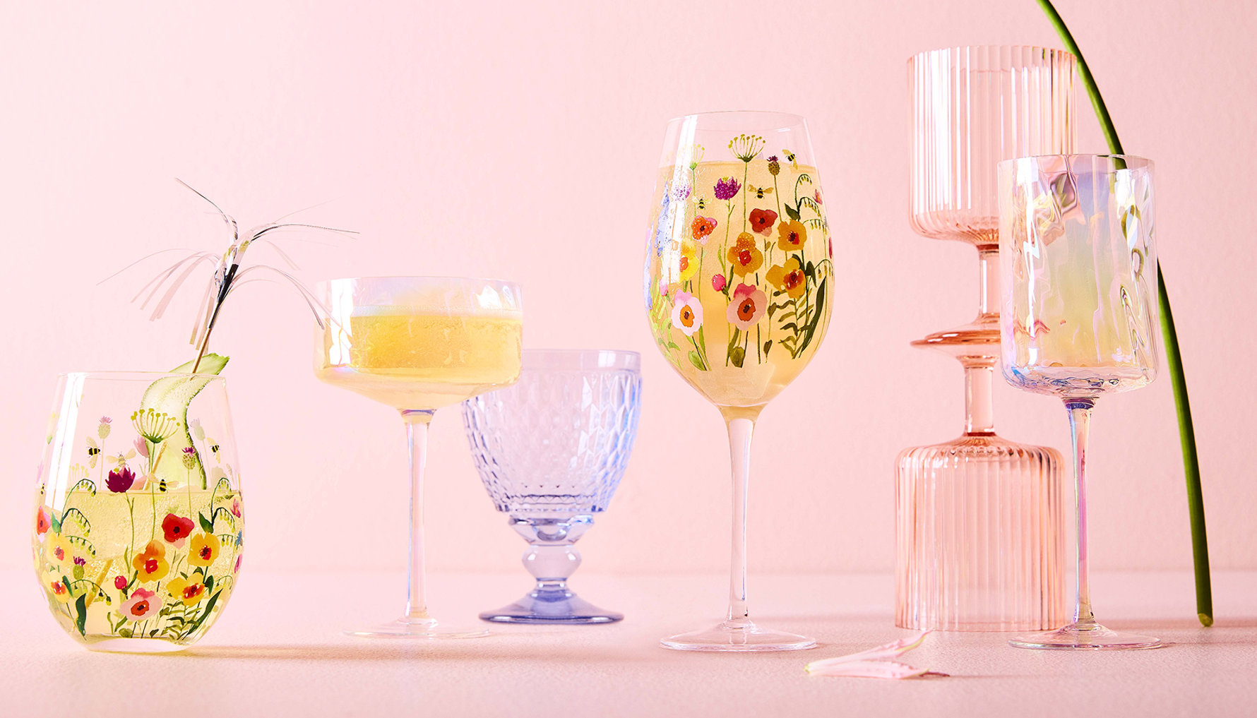 Une variété de verrerie décorative sur une surface rose.