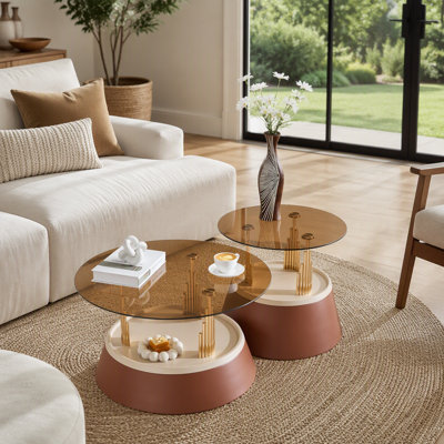 Ensemble de tables basses gigognes brunes et dorées d'inspiration luxueuse. Ensemble de tables basses à deux niveaux avec verre trempé teinté au thé. Table basse ronde de salon, ensemble de deux pièces.