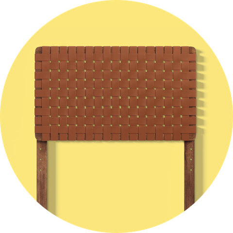 A brown woven leather headboard with wooden legs, showcased on a circular yellow background.