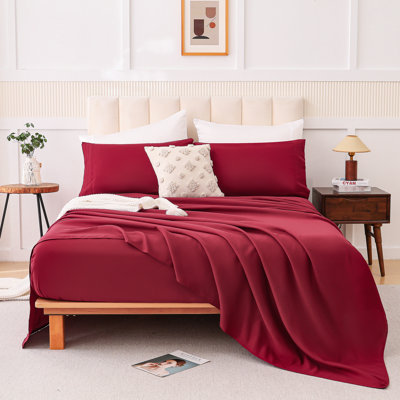 Ensemble quatre pièces rouge bordeaux, en mélange de coton doux pour dormir à même la peau, avec bords renforcés, tons discrets pour décorer la chambre, taille standard, impression et teinture rouges respectueuses de l'environnement.