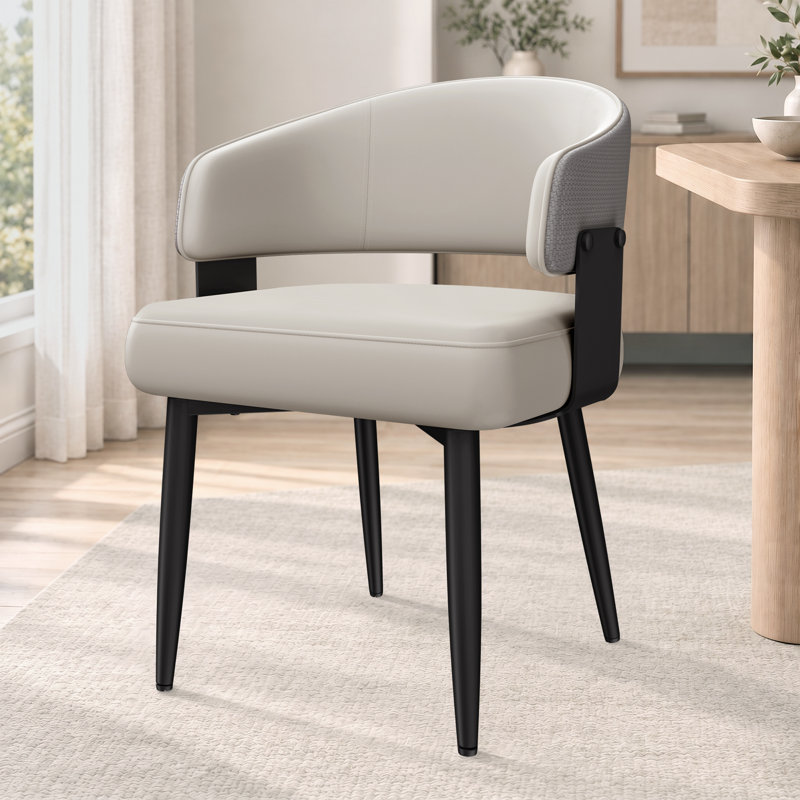 Chaise de salle à manger moderne rembourrée, hauteur du siège de 47 cm (18,5 pouces), dossier enveloppant incurvé, assise épaisse et pieds en métal noir.