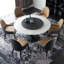 Table de salle à manger blanche et noire avec pierres rondes et feuilles en acier-107786110